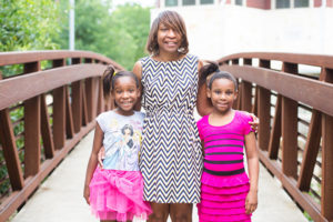 Black family, mother and two daughters, standing on a bridge