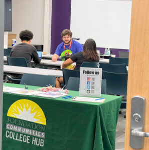 A college hub advisor working with students in a classroom